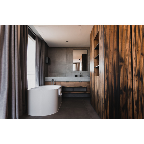 Modernes Badezimmer mit einer weißen Badewanne, Holzwänden, grauen Vorhängen und einem großen Spiegel über dem Waschbecken.