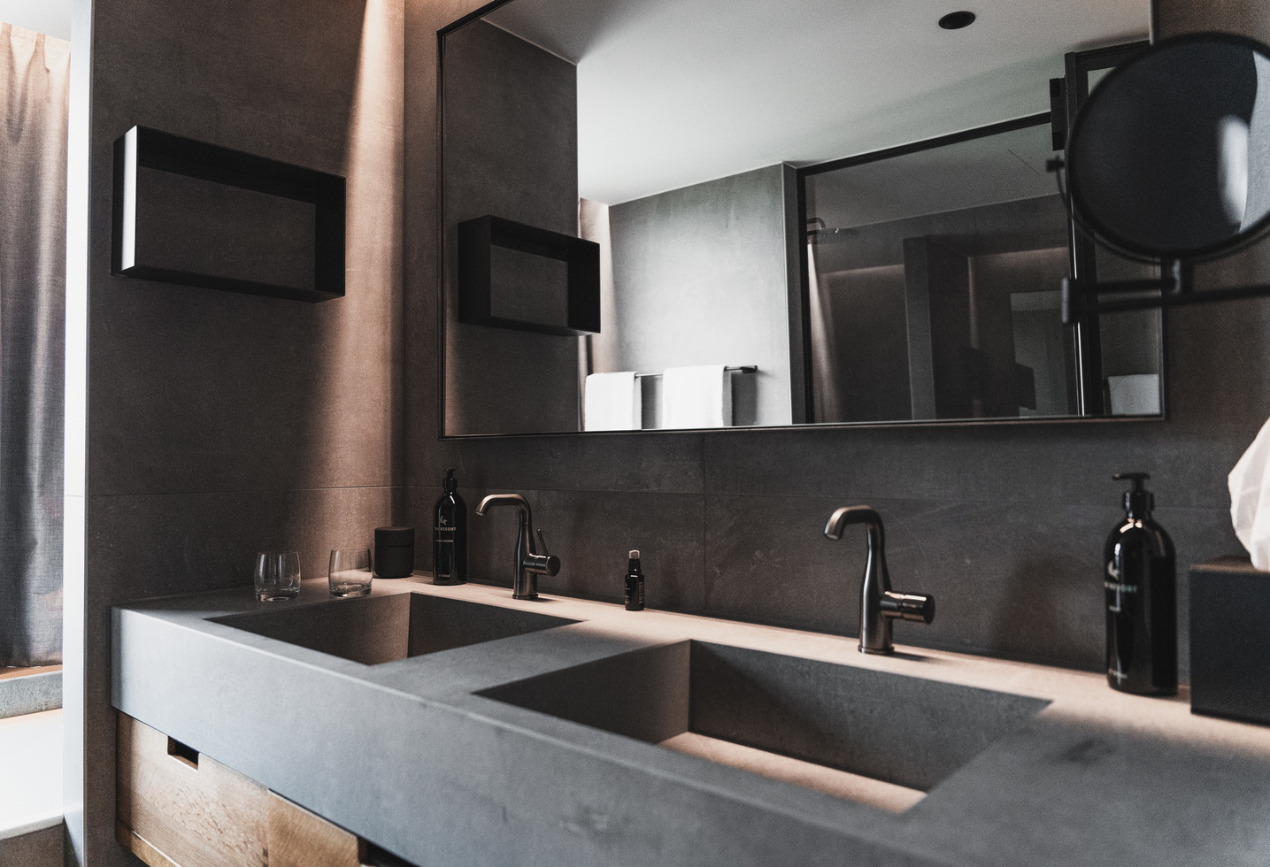 Modernes Bad mit zwei Waschbecken, großem Spiegel, schwarzen Armaturen und minimalistischem Dekor in neutralen Tönen.